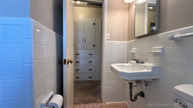 bathroom featuring tile patterned flooring, tile walls, toilet, and tasteful backsplash