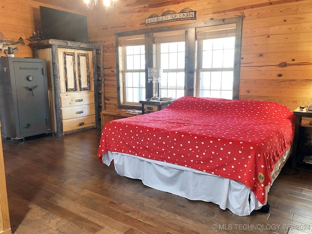 bedroom with wooden walls and dark hardwood / wood-style flooring