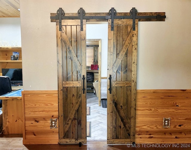 interior space featuring a barn door and parquet flooring