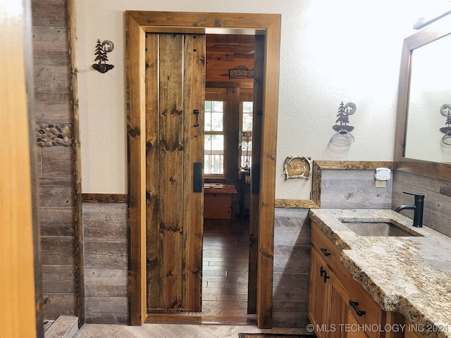 bathroom with wood walls and vanity