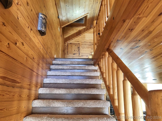 stairway with wood walls and wooden ceiling