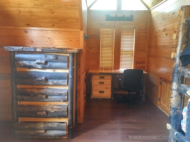 unfurnished office with dark wood-type flooring, vaulted ceiling, plenty of natural light, and wooden walls