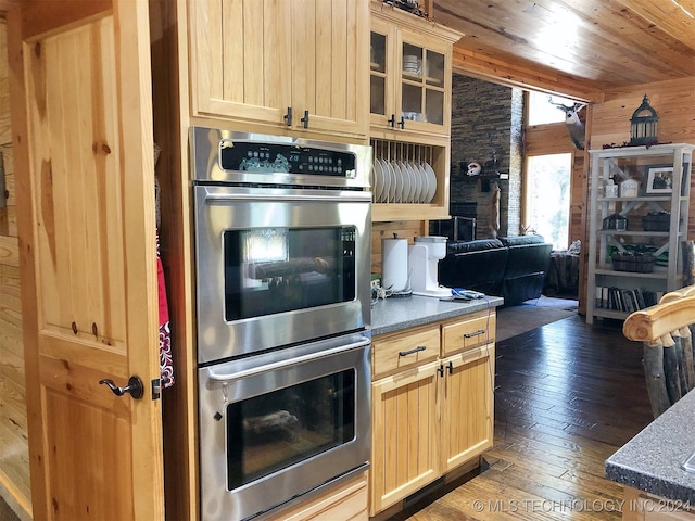 kitchen featuring wood ceiling, light brown cabinets, dark hardwood / wood-style floors, and stainless steel double oven