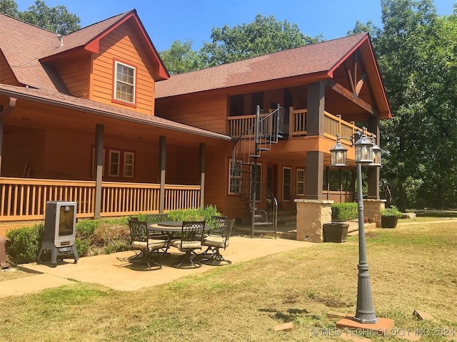 back of house with a balcony, a yard, and a patio