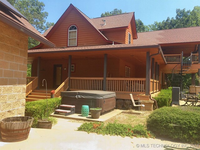 view of front of property with a hot tub and a patio