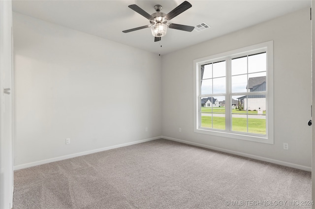 carpeted spare room featuring ceiling fan