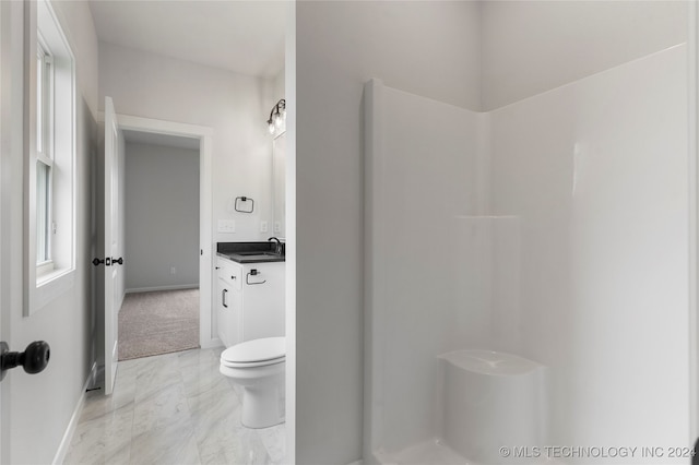 bathroom featuring vanity, toilet, and walk in shower