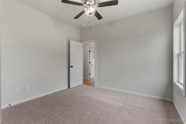 spare room featuring light carpet and ceiling fan