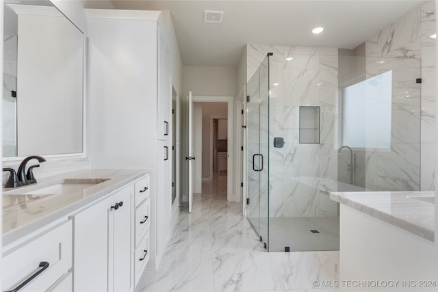 bathroom featuring a shower with shower door and vanity