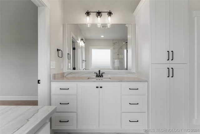 bathroom featuring walk in shower and vanity