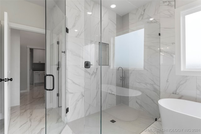 bathroom featuring tile walls and independent shower and bath