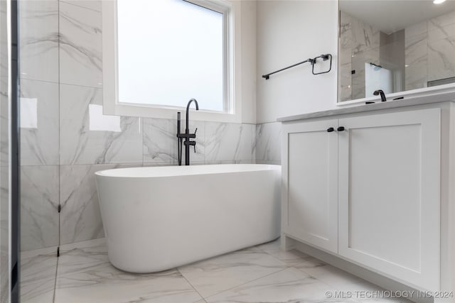 bathroom with vanity, tile walls, and separate shower and tub