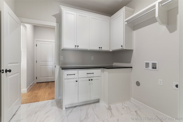 clothes washing area with hookup for a washing machine, light hardwood / wood-style flooring, cabinets, and hookup for an electric dryer