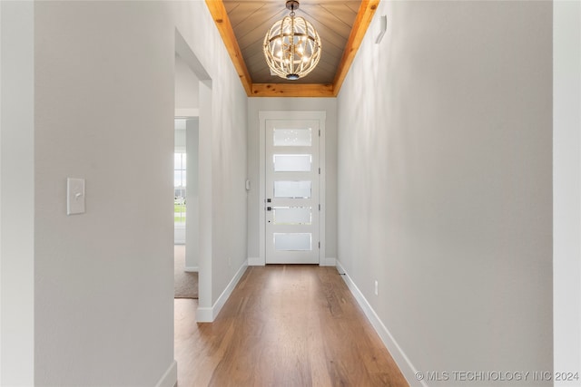 entryway featuring light wood-type flooring, a chandelier, and wooden ceiling