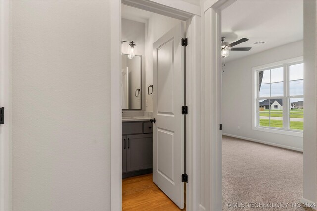 hallway featuring light colored carpet