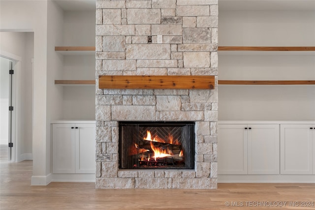 interior details with hardwood / wood-style floors and a stone fireplace