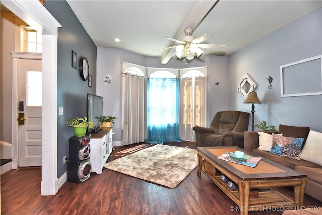 living room featuring dark wood-type flooring and ceiling fan