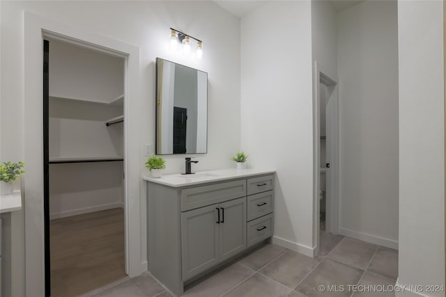 bathroom with toilet, vanity, and tile patterned floors