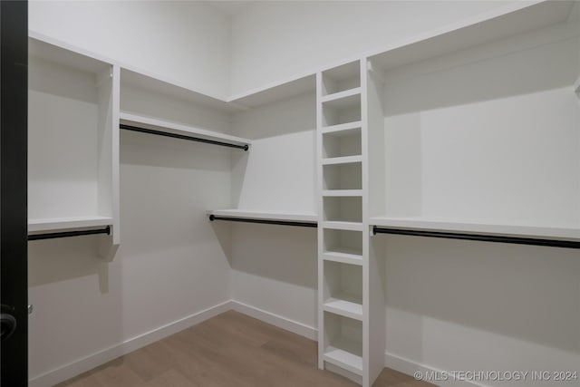 walk in closet with wood-type flooring