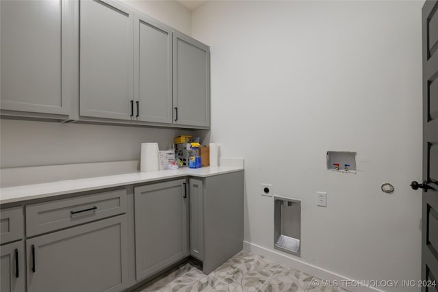 laundry room featuring electric dryer hookup, light tile patterned floors, cabinets, and washer hookup