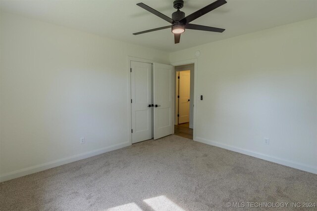 unfurnished room with ceiling fan and light colored carpet