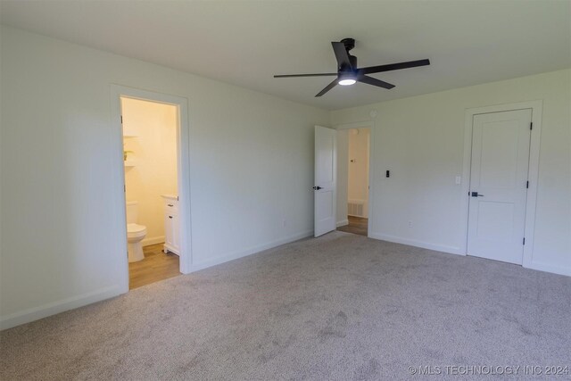 unfurnished bedroom with light carpet, ensuite bathroom, and ceiling fan