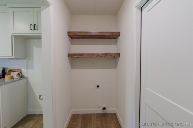 laundry area featuring wood-type flooring and electric dryer hookup