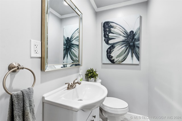 bathroom with toilet, ornamental molding, and vanity