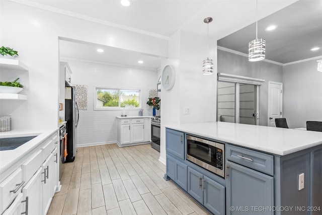 kitchen with hanging light fixtures, stainless steel appliances, light hardwood / wood-style floors, white cabinetry, and ornamental molding