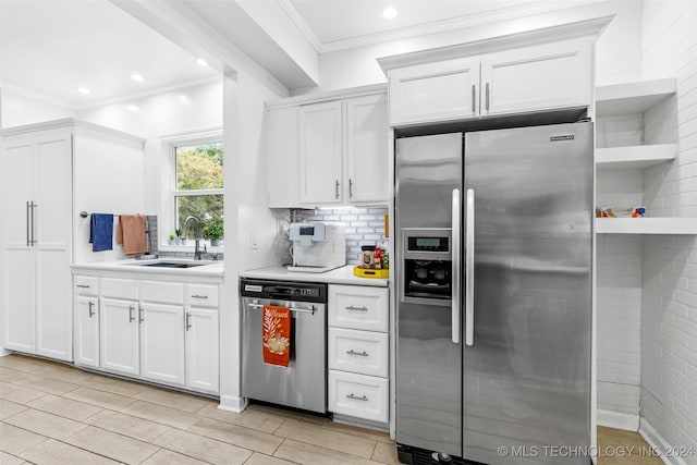 kitchen featuring backsplash, stainless steel appliances, white cabinetry, and sink