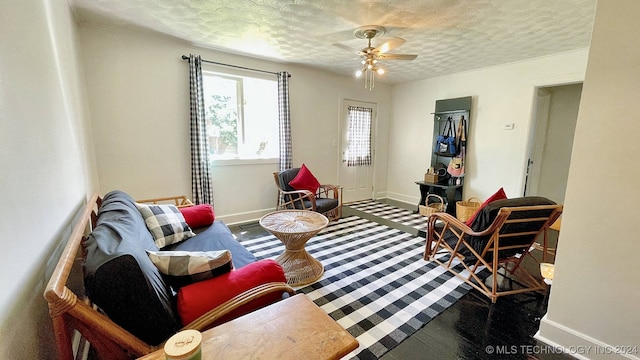 living room featuring ceiling fan and a textured ceiling