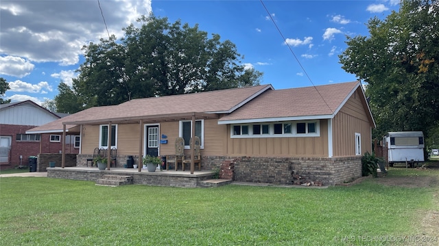 rear view of property with a patio and a yard