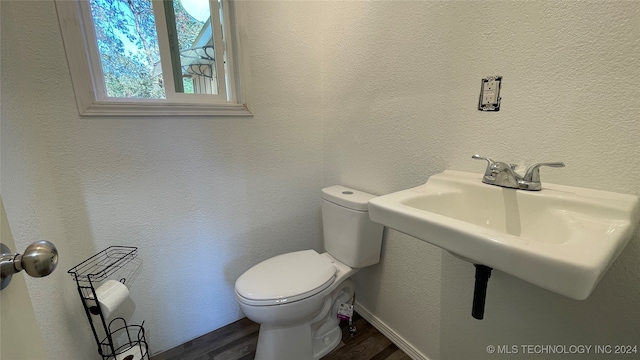 bathroom with toilet and hardwood / wood-style floors