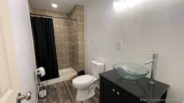 bathroom with toilet, curtained shower, vanity, and wood-type flooring