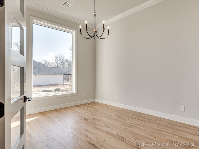 unfurnished room with light hardwood / wood-style flooring, ornamental molding, and a notable chandelier