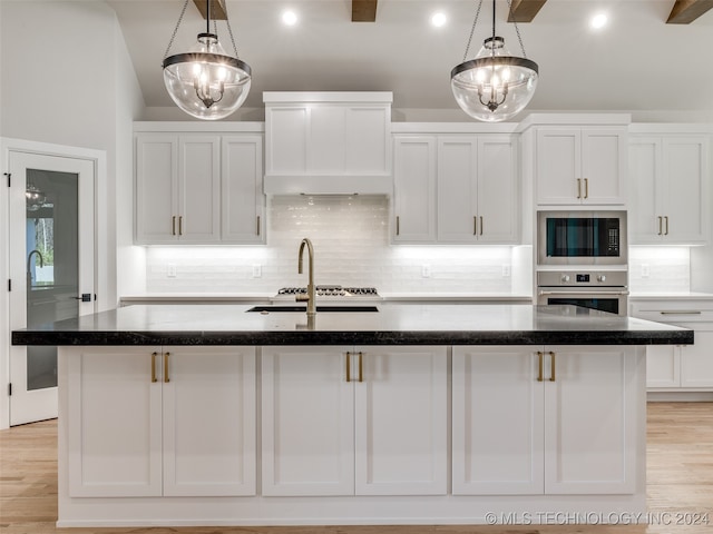 kitchen with white cabinets, pendant lighting, oven, and a notable chandelier