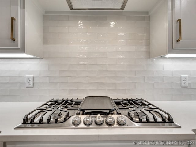 kitchen with ventilation hood, stainless steel gas cooktop, and tasteful backsplash