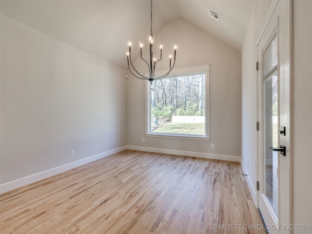 unfurnished dining area featuring an inviting chandelier, vaulted ceiling, and light wood-type flooring