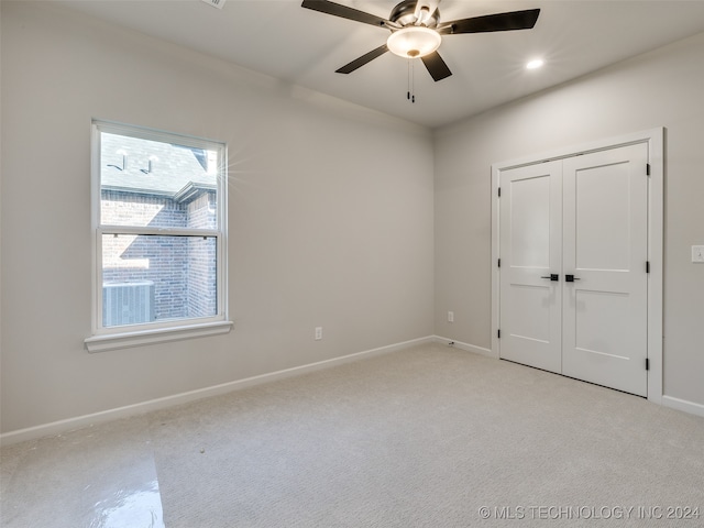 unfurnished bedroom with light carpet, a closet, and ceiling fan