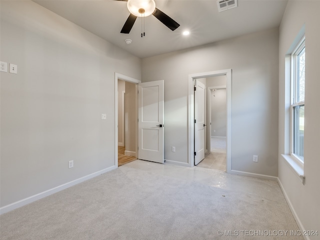 unfurnished bedroom with light carpet and ceiling fan