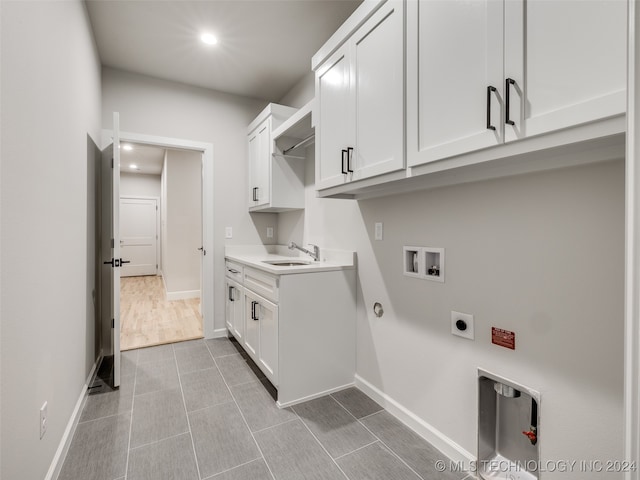 laundry room with electric dryer hookup, sink, cabinets, and washer hookup