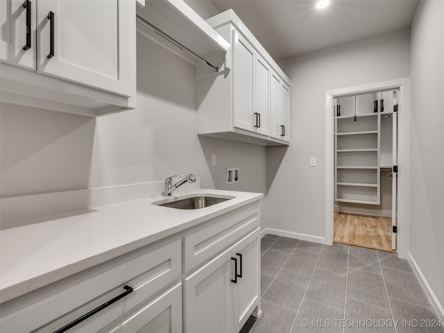 clothes washing area featuring cabinets, sink, and hookup for a washing machine