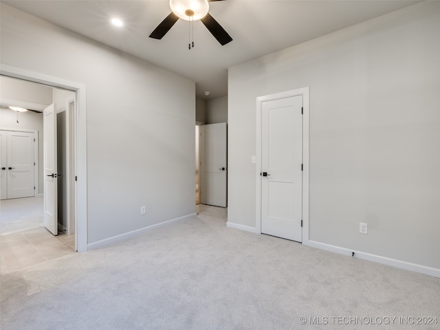 unfurnished bedroom with ceiling fan and light colored carpet