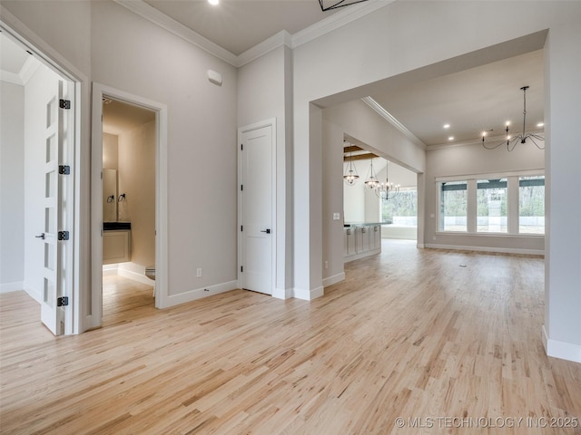 unfurnished room featuring an inviting chandelier, ornamental molding, and light hardwood / wood-style floors