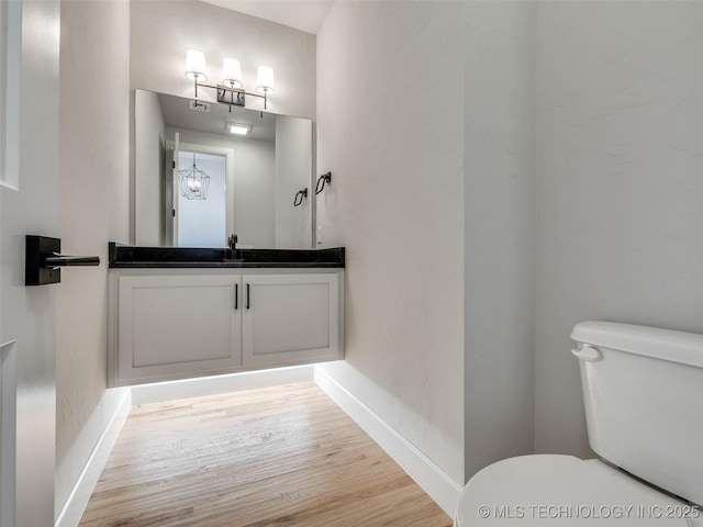 bathroom featuring vanity, hardwood / wood-style floors, and toilet