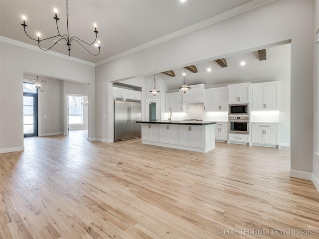 kitchen with crown molding, built in appliances, a chandelier, decorative light fixtures, and white cabinets