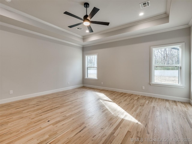 unfurnished room featuring crown molding, a tray ceiling, light hardwood / wood-style flooring, and ceiling fan