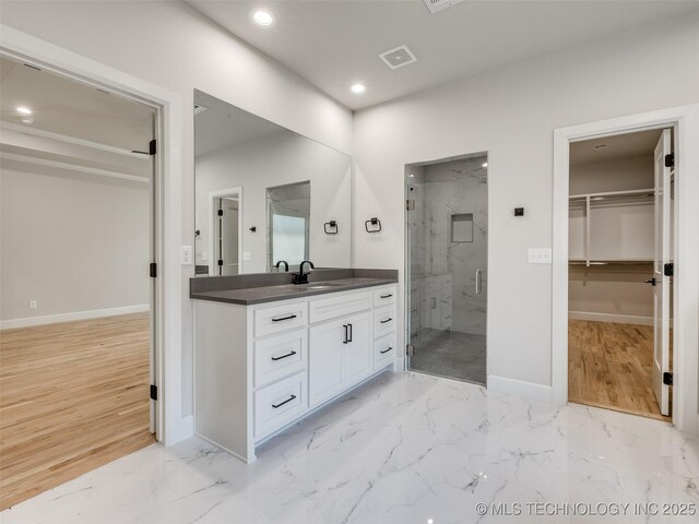 bathroom with vanity and a shower with door