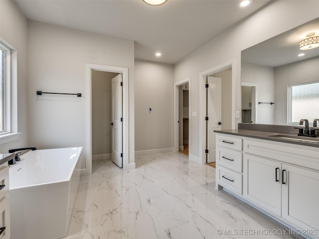 bathroom featuring vanity and a washtub