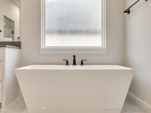 bathroom with plenty of natural light and a bath